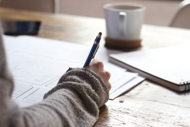 Person holding a pen writing a checklist